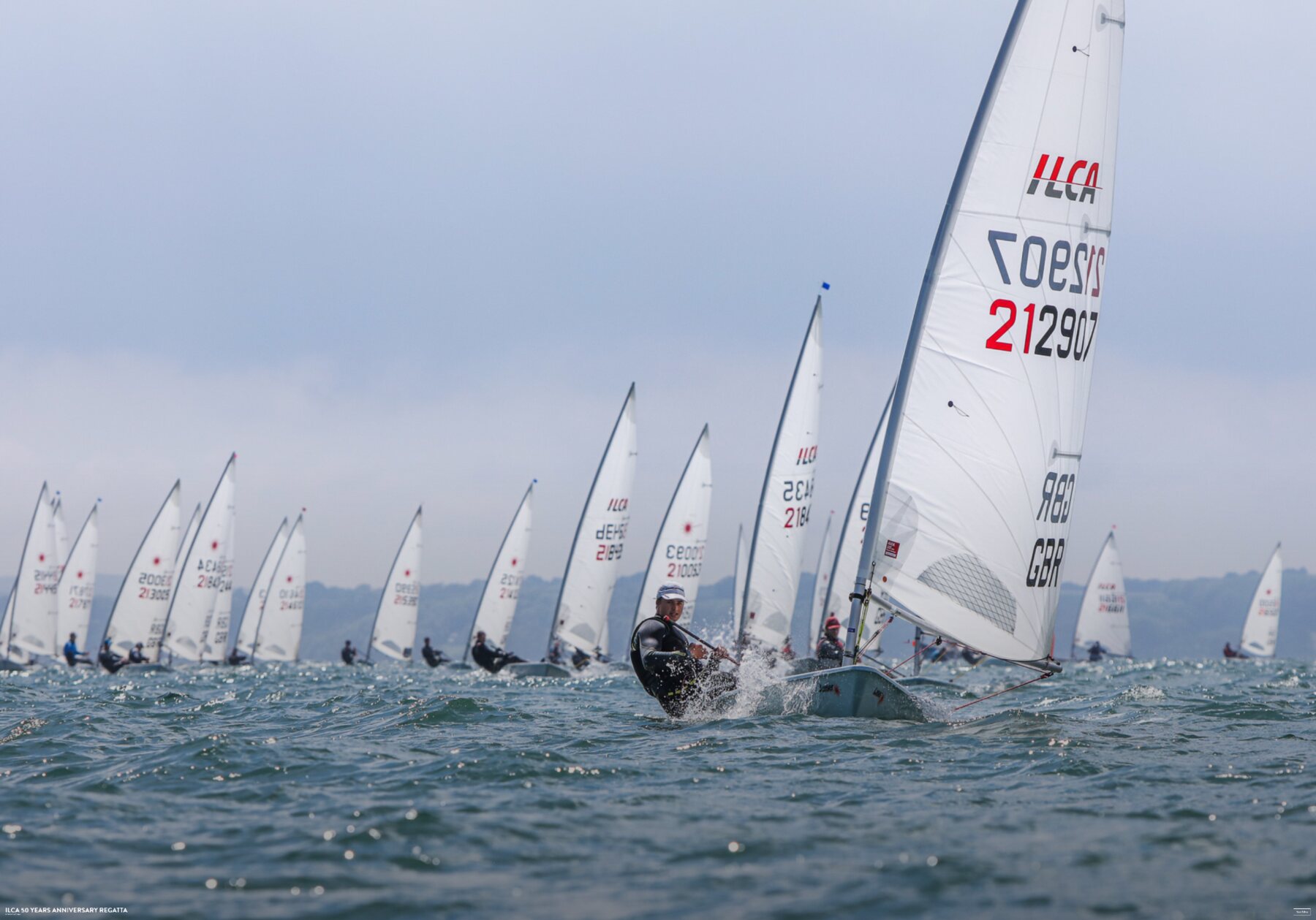 A large ILCA fleet racing in open water